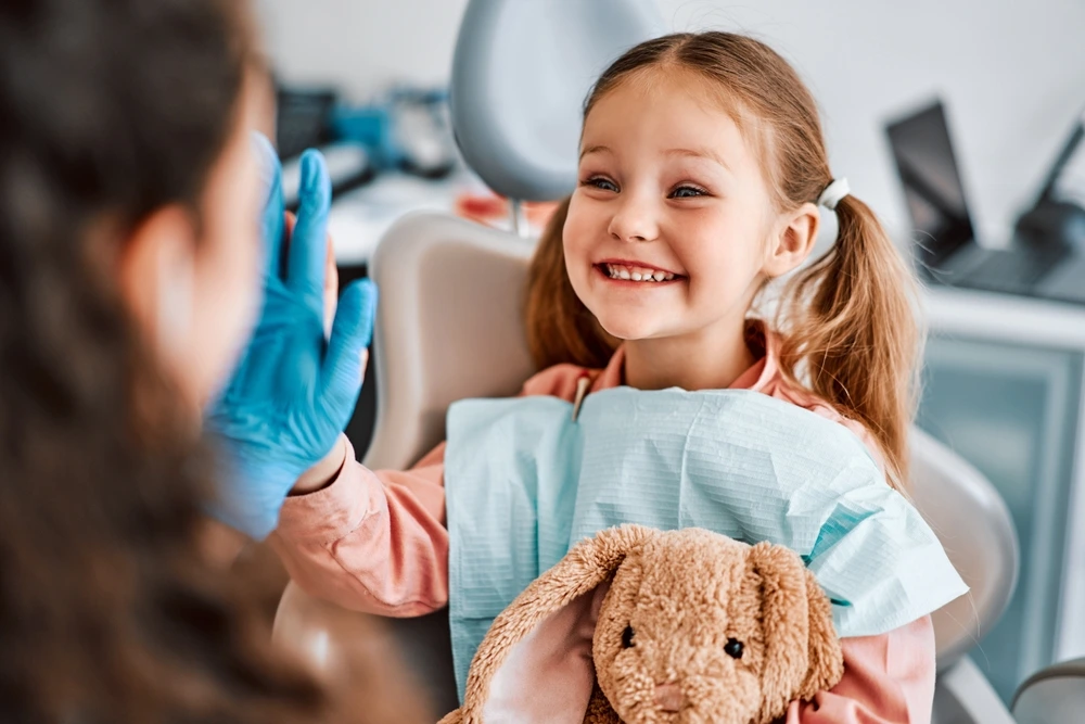 A young female patient of City Family Dental Care is happy while talking to her dentist