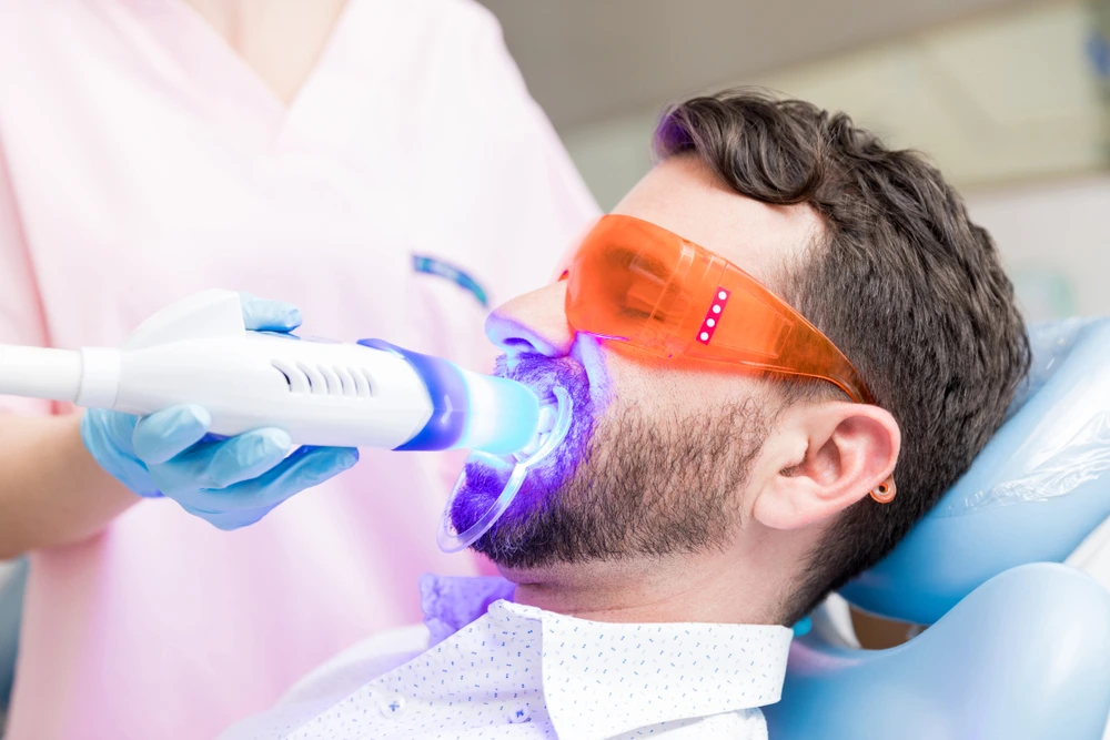 A male patient of City Family Dental Care is under teeth whitening treatment